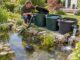 Selbst gebauter Teichfilter aus Kunststoffbehältern mit Teichpumpe und Rücklauf am Gartenteich